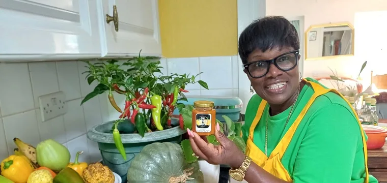 Donna sharing her homemade pepper sauce and fresh produce